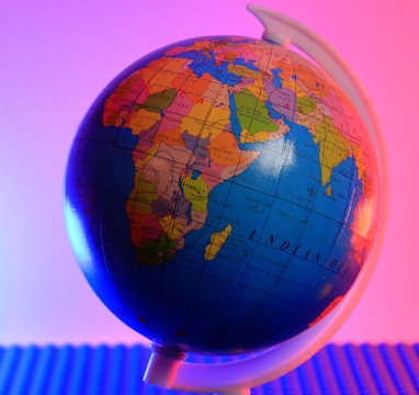 a blue and orange globe with a pink background