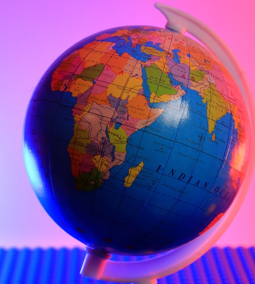 a blue and orange globe with a pink background