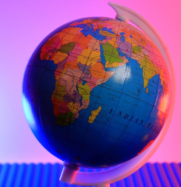 a blue and orange globe with a pink background