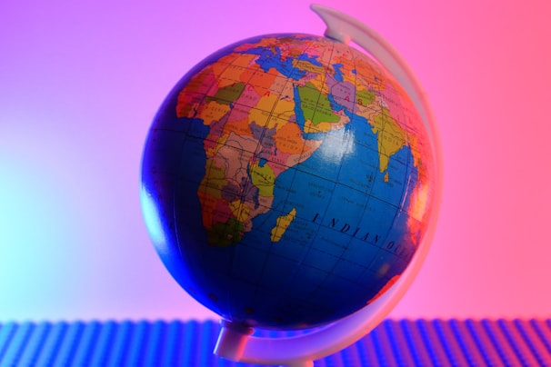 a blue and orange globe with a pink background