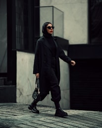 A stylish professional carrying a leather bag in an urban setting, exuding confidence and sophistication.