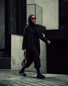 A stylish man and woman walking confidently in a modern urban setting.