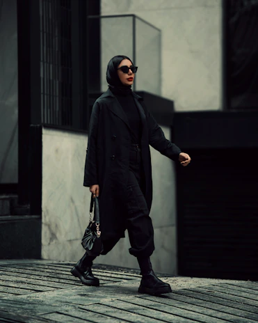 A stylish individual confidently walking down a city street wearing a modern, elegant outfit from Fine Modern Options.