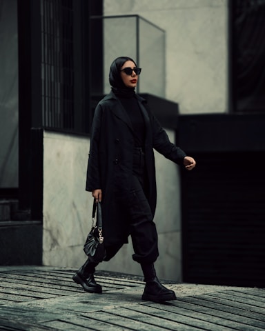 A stylish professional carrying a leather bag in an urban setting, exuding confidence and sophistication.