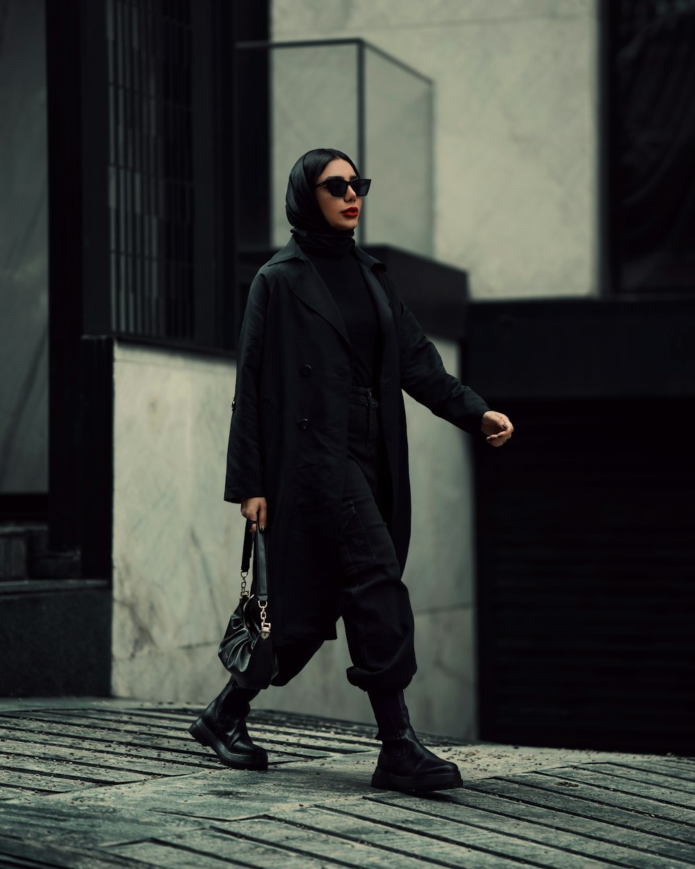 a woman walking down a street holding a handbag