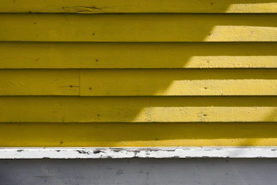 A freshly painted yellow wall with clean edges and a glossy finish in a kitchen