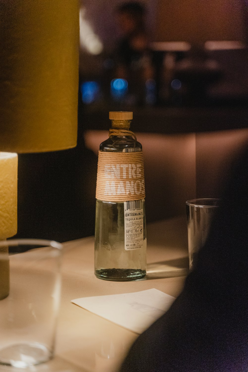 a bottle of water sitting on a table next to a lamp