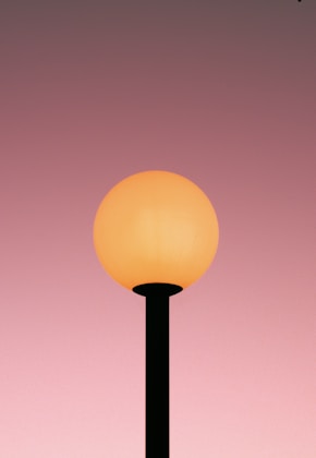 a street light with a pink sky in the background