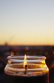 Close-up of a candle flame flickering softly inside a glass jar.
