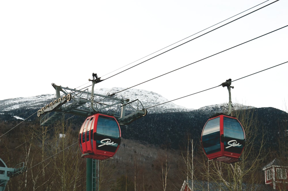 um teleférico subindo uma colina com uma montanha ao fundo