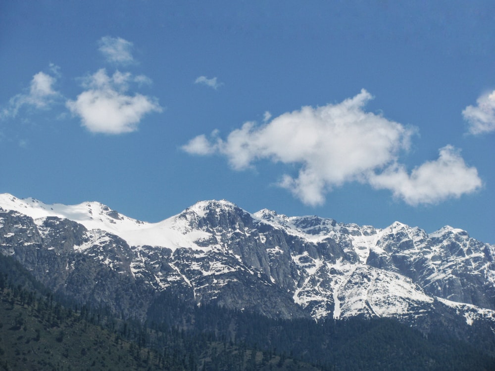 a snow covered mountain range under a blue sky