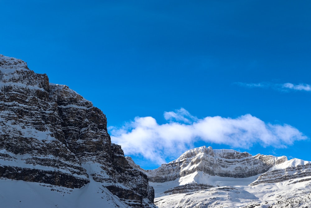 Ein schneebedeckter Berg mit blauem Himmel im Hintergrund