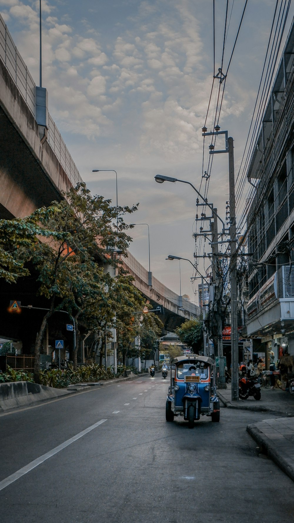 a car driving down a street next to a tall building