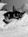 A small dog comfortably resting on a soft, quilted pillow. Its eyes appear relaxed and sleepy, conveying a sense of coziness and tranquility.