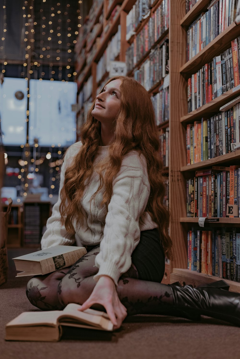 a woman sitting on the floor reading a book