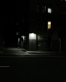 A dimly lit urban street corner at night, evoking solitude and mystery in line with the noir theme.
