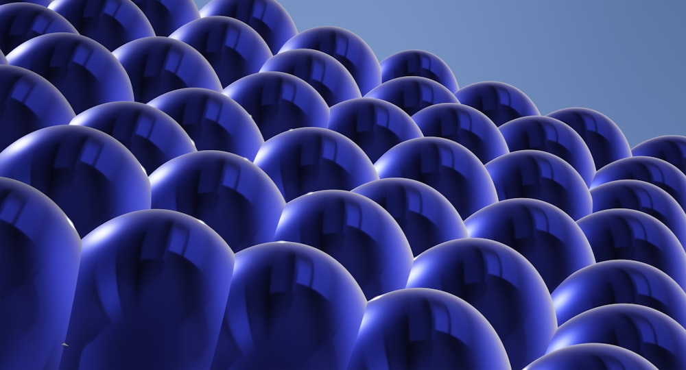 a large group of blue balls with a blue sky in the background