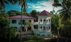 A sleek modern luxury villa with floor-to-ceiling windows overlooking a lush green garden in Goa.