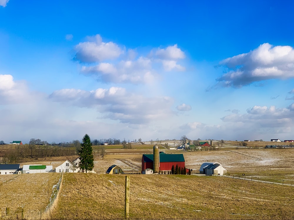 a farm with a barn and silo in the background