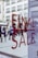 Large red letters spelling 'FINAL SALE' are displayed on a glass window. In the background, a busy pedestrian area can be seen with people walking and historic buildings in view, slightly blurred, creating a sense of movement and activity.