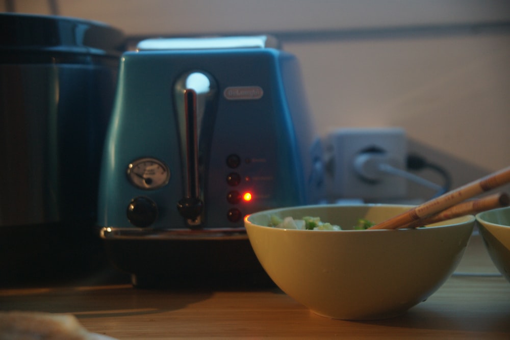 a bowl of food with chopsticks in it next to a blender