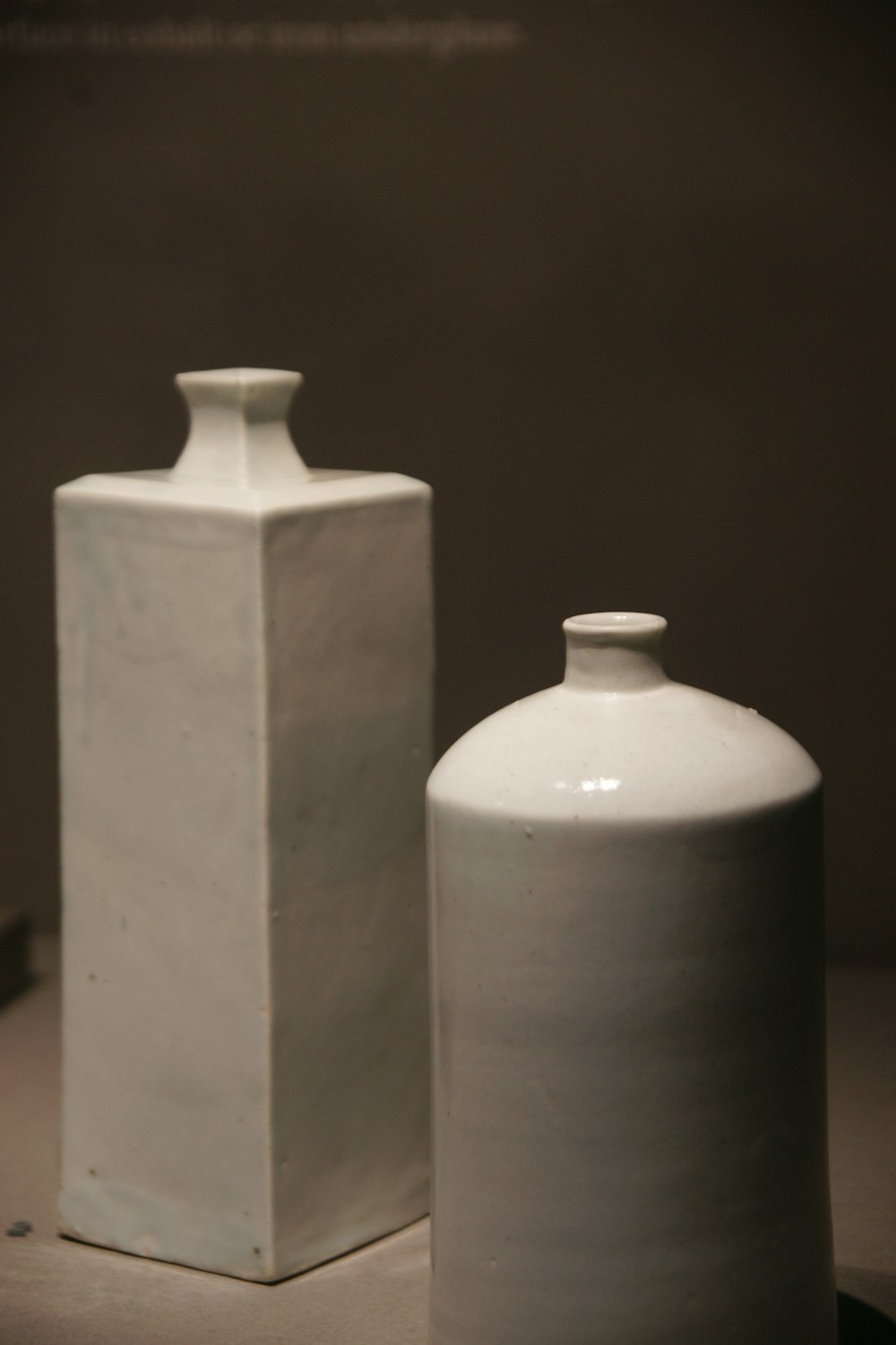 a couple of white vases sitting on top of a table