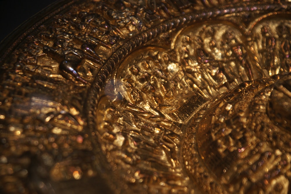 a close up of a gold plate with intricate designs
