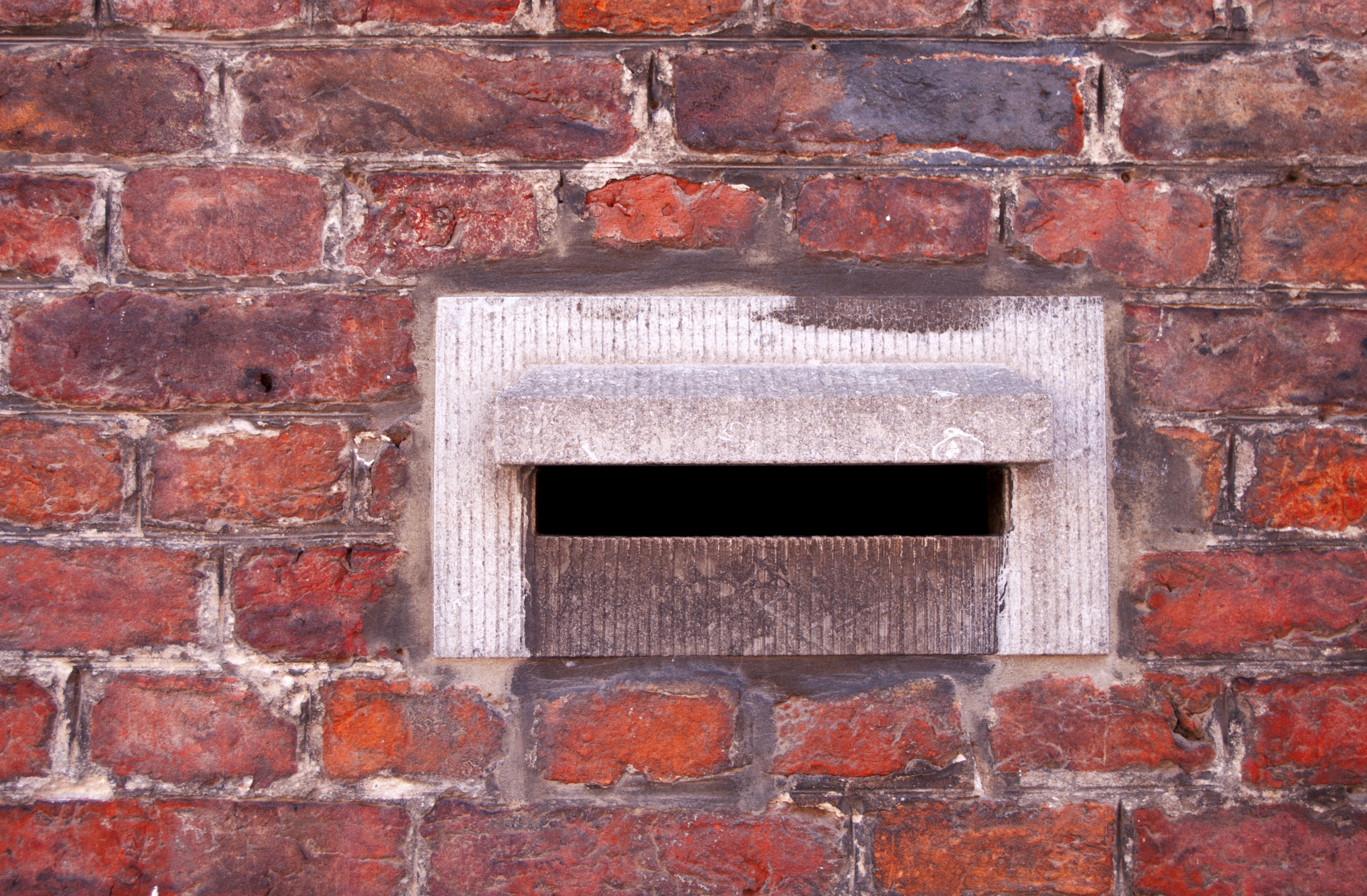 a close up of a brick wall with a small window