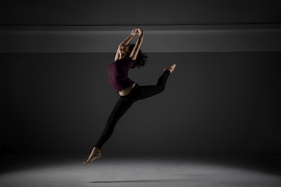 Modern dancer in mid-air leap wearing casual dancewear.