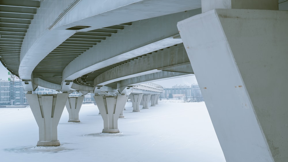 the underside of a bridge with snow on the ground