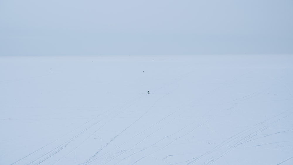 a person walking across a snow covered field