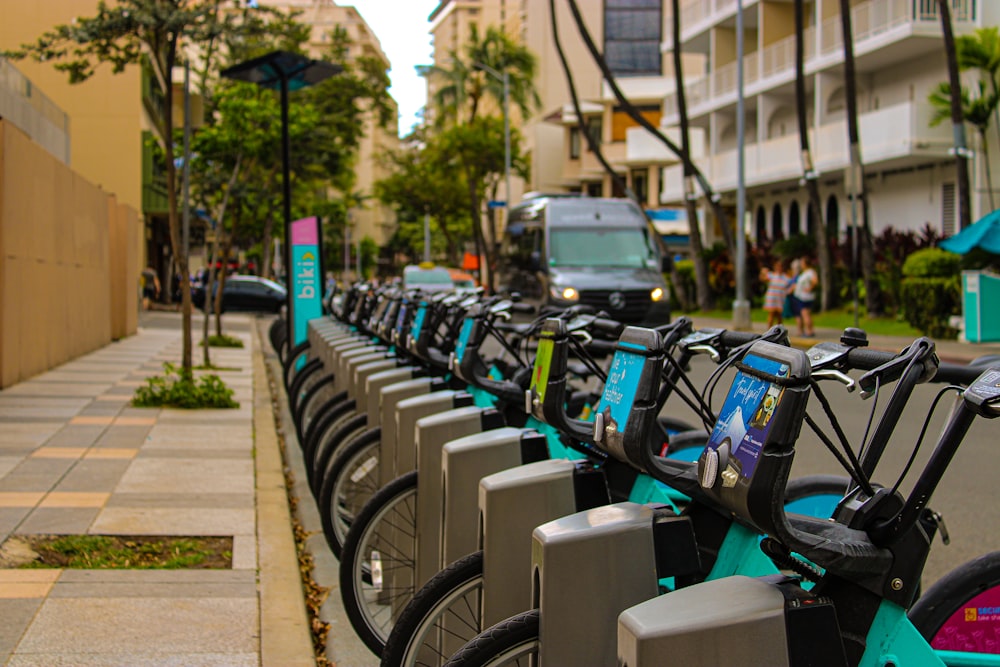 a row of bikes parked next to each other on a sidewalk