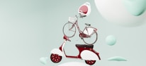 A whimsical arrangement featuring a red and white scooter with a vintage look at the bottom, a classic red bicycle with a front basket stacked on top, and a futuristic white and red helmet-like pod on top of the bicycle. They appear to be floating against a soft pastel green background with abstract rounded shapes and spheres creating an imaginative scene.