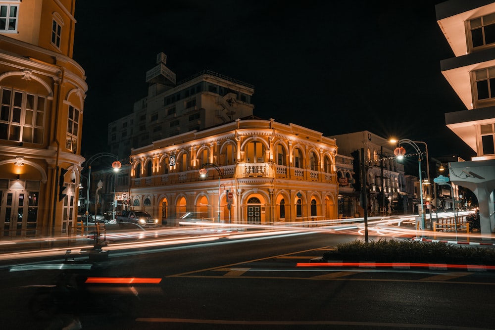 Una calle de la ciudad por la noche con un edificio iluminado