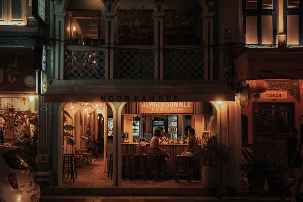 a night time view of a restaurant in a city