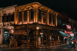 a group of people standing outside of a building at night