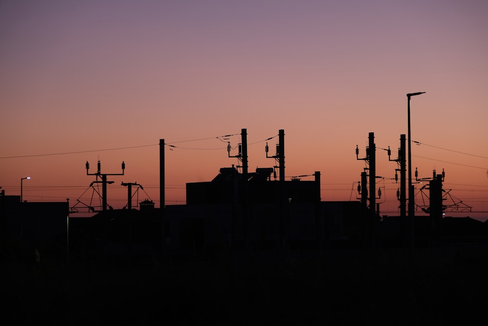 a silhouette of power lines against a sunset sky