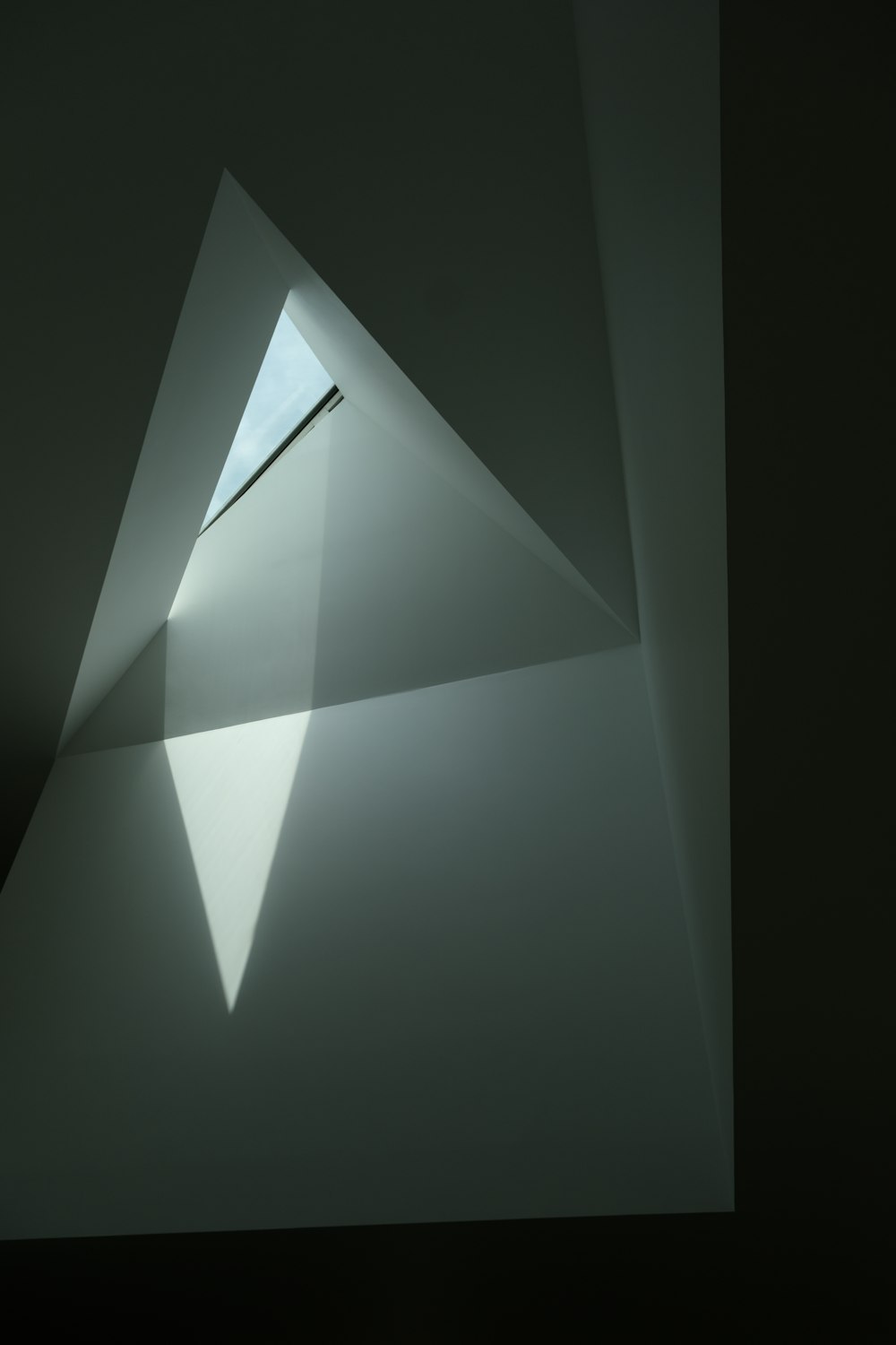 a white wall with a triangular shaped window