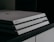 A close-up image of a Sony PlayStation 4 gaming console, featuring a sleek, tiered design with a matte finish and the Sony logo imprinted on the front.