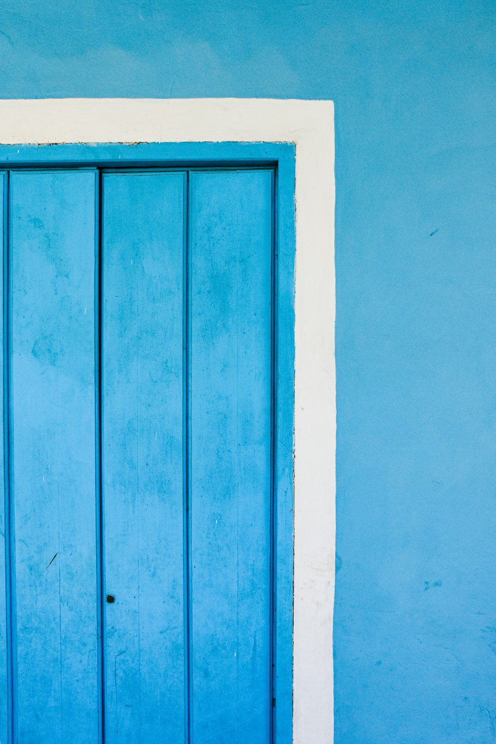 a blue door with a white frame on a blue wall