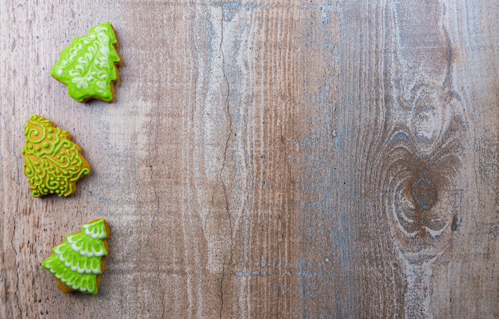 three decorated cookies sitting on top of a wooden table