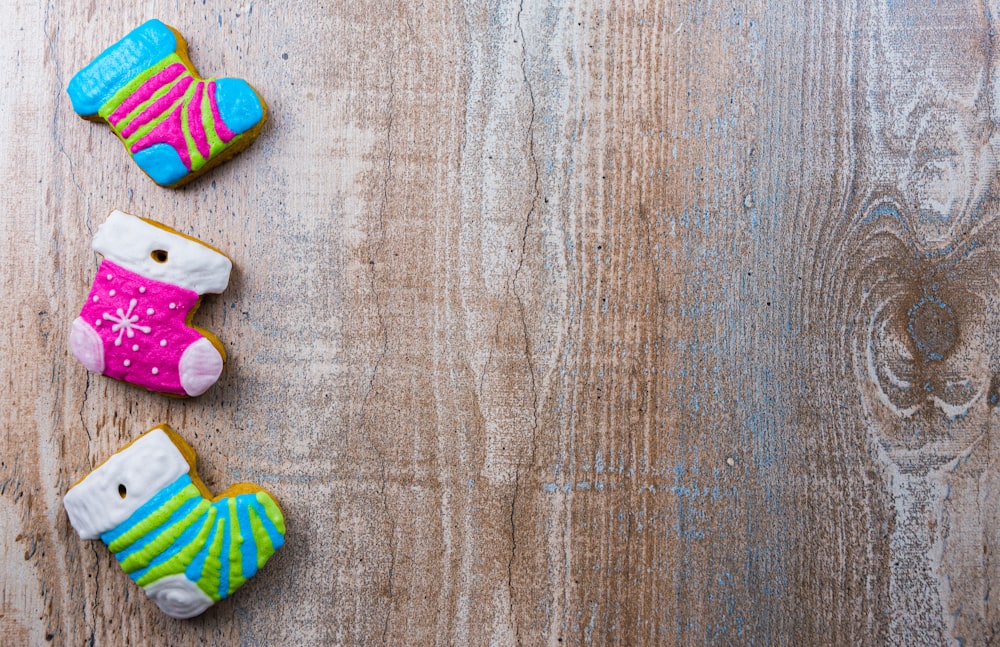 three decorated cookies sitting on top of a wooden table