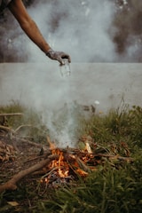 A user safely operating a compact smokeless incinerator outdoors.