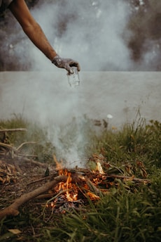 A user safely operating a compact smokeless incinerator outdoors.