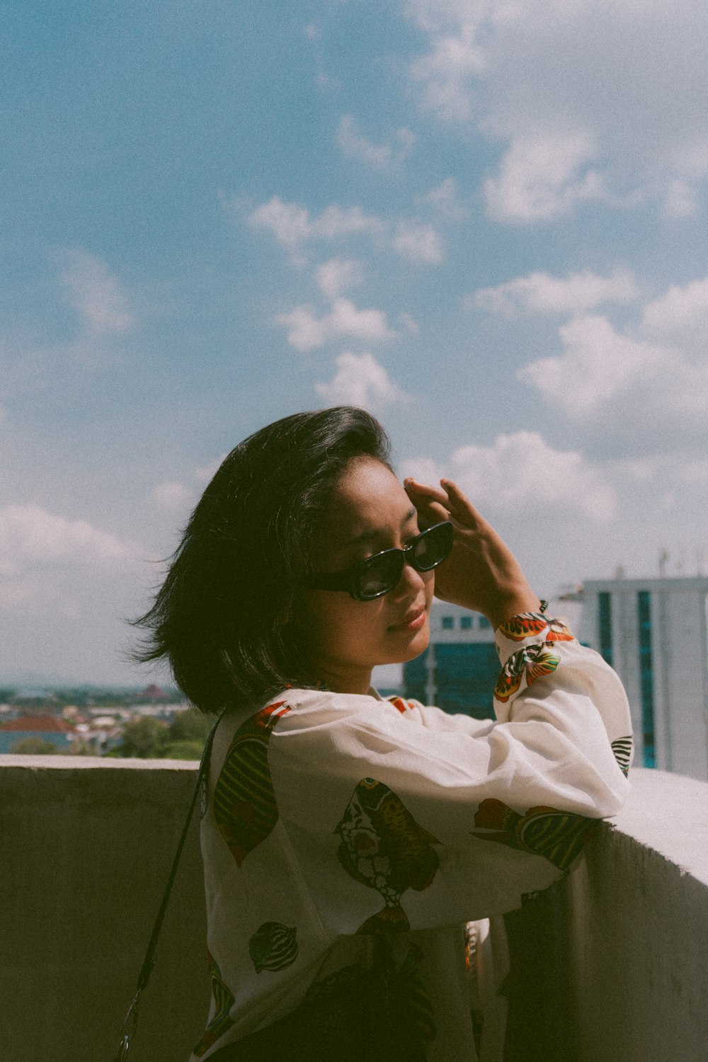 a woman leaning against a wall with her hand on her head