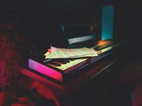 A moody, midnight-purple themed photo of Kazi Munif Ahmed at the piano, softly lit.