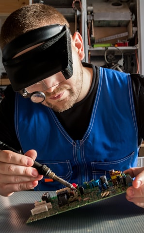 a man wearing a blindfold working on a circuit board