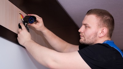 a man working on a wall with a screwdriver