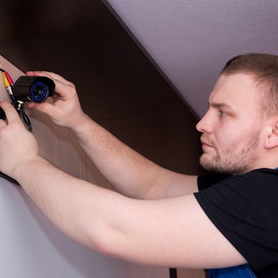 a man working on a wall with a screwdriver