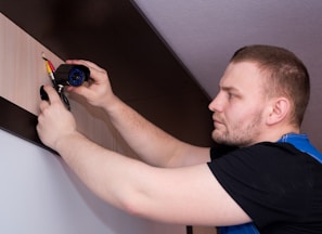 a man working on a wall with a screwdriver